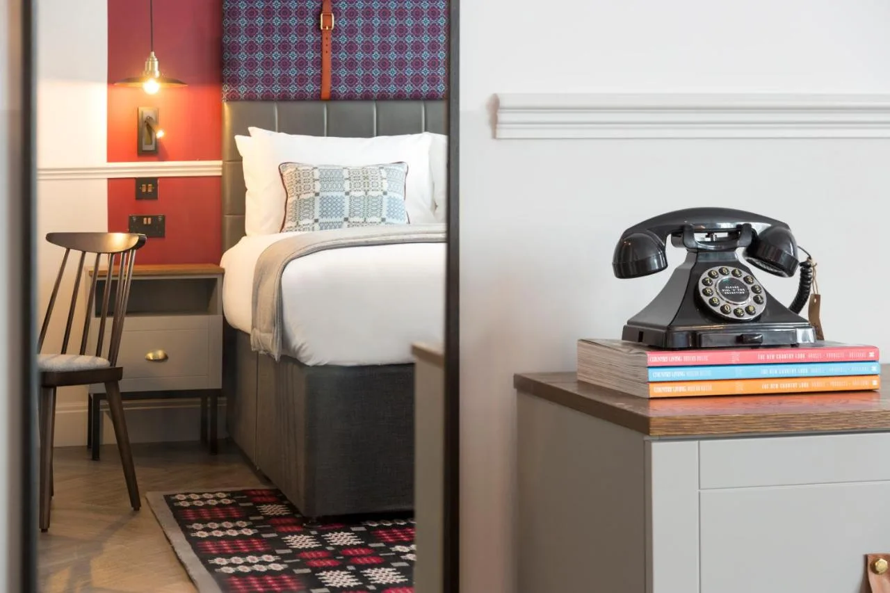 Comfortable guest bedroom with bed and telephone at Hotel Indigo Cardiff